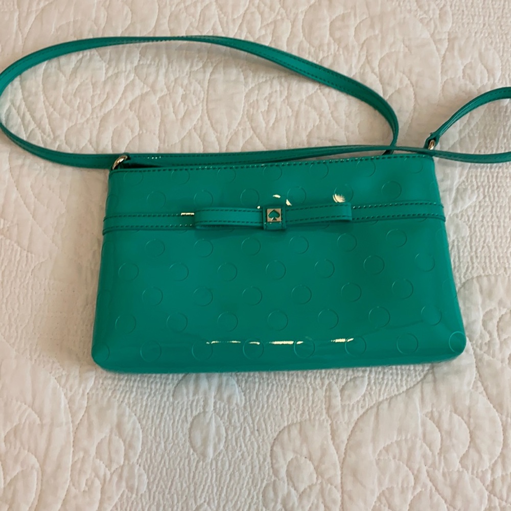 Kate Spade teal/turquoise polyvinyl crossbody purse in good condition.